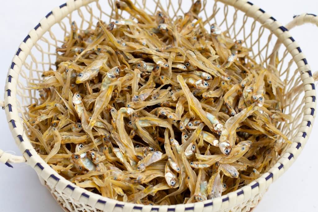 Dried fish in basket on white background