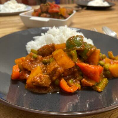 Pork-Mechado-on-Brown-plate-with-Rice-with-Pork-Mechado-on-serving-plate-in-background